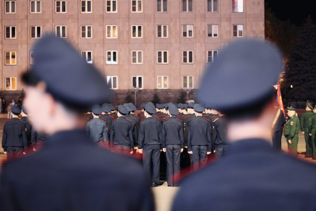 Eine Gruppe uniformierter Männer steht vor einem Gebäude
